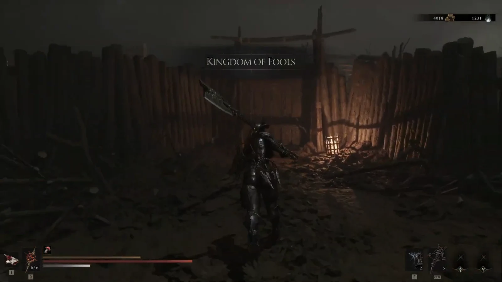 Character advancing toward a torchlit wooden gate inside the Kingdom of Fools village