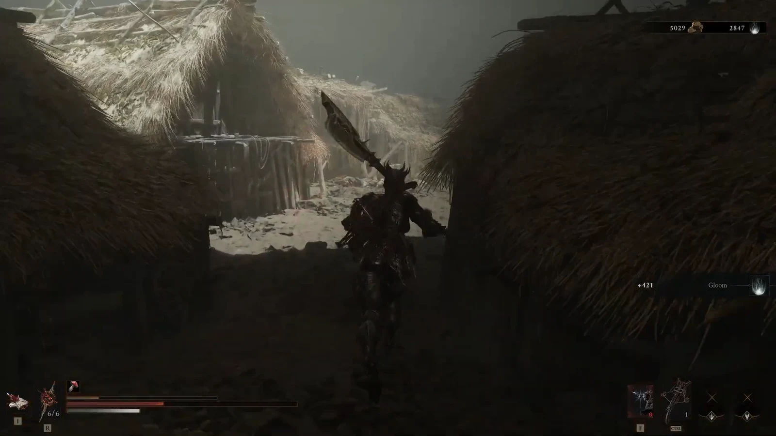 Character with a large sword moving through a narrow passage between thatched huts