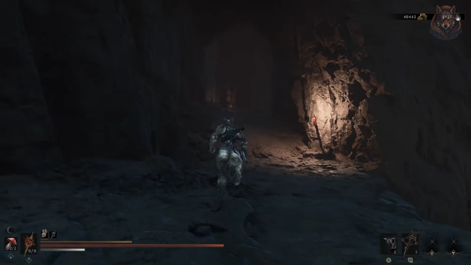 Armored shell moving through a dark cave passage toward a torchlit opening in Garrick's Den