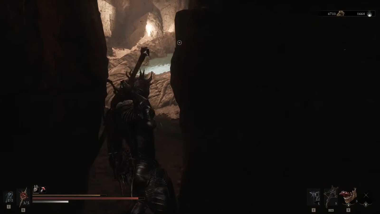 Armored character moving through a narrow cavern gap toward a glowing opening with the HUD visible