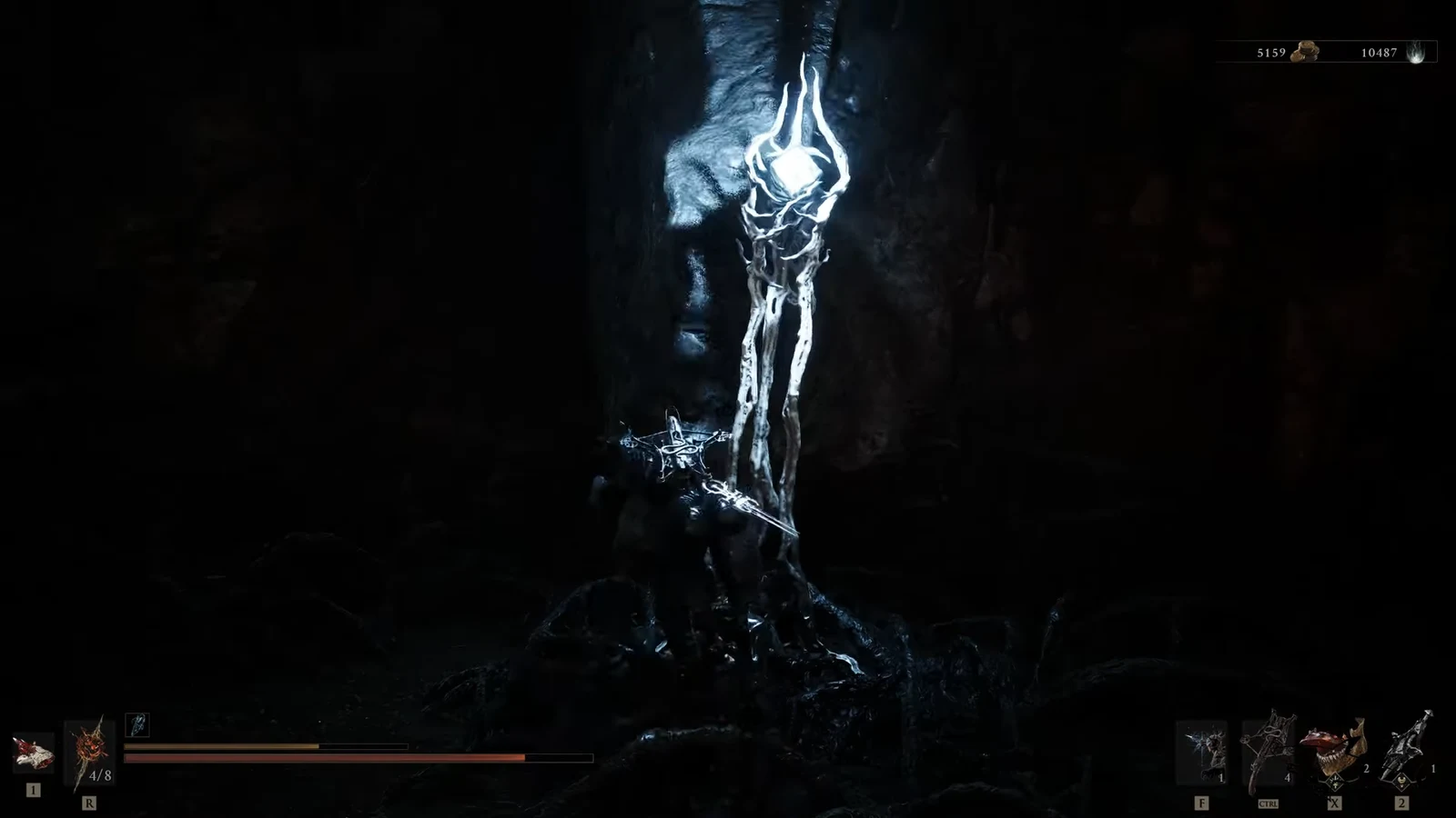 Player approaching a glowing skeletal structure in a dark cavern with the combat HUD visible