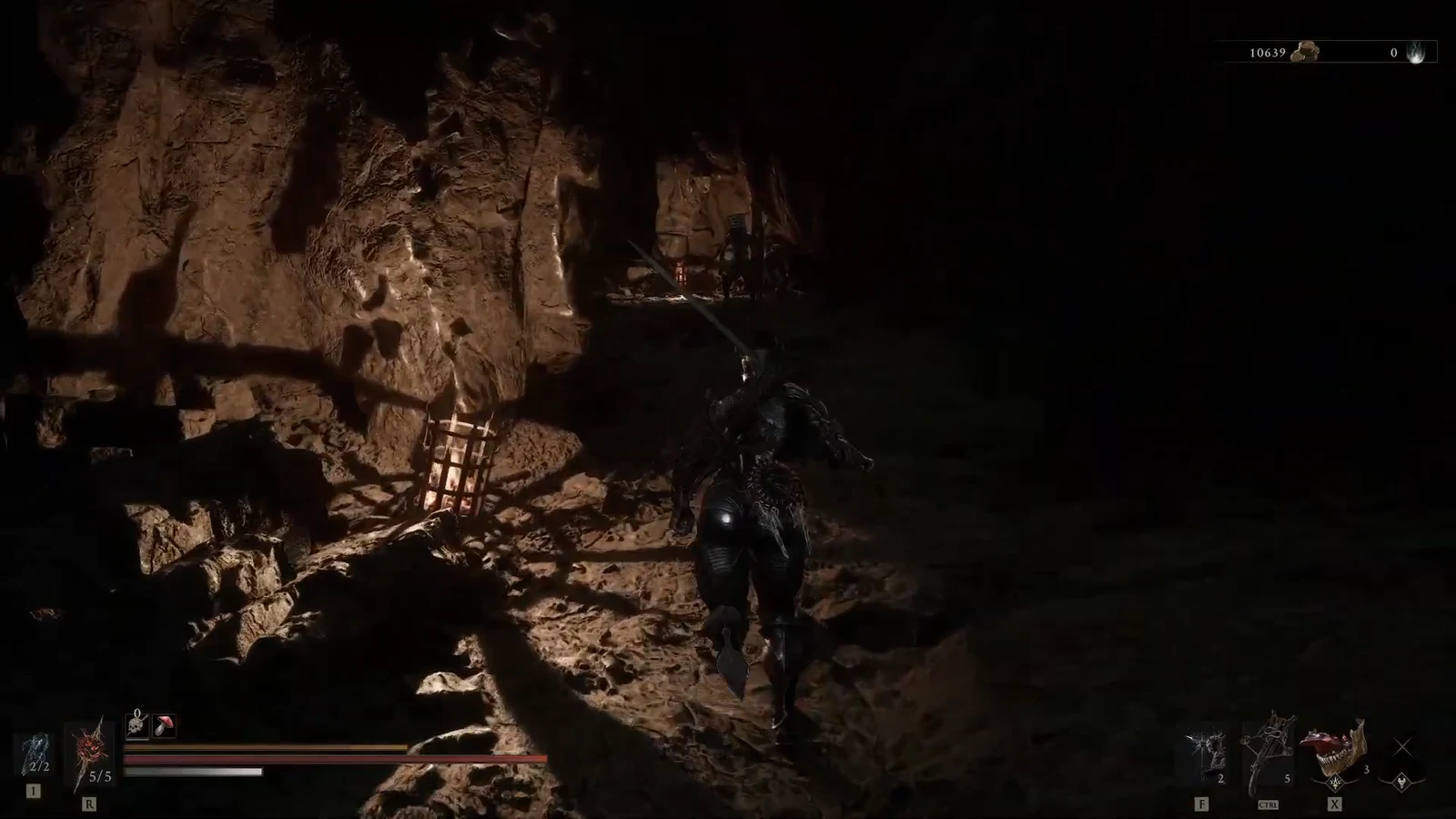 Character moving through a torchlit cave toward a raised wooden platform in the Burrowkin Dwelling