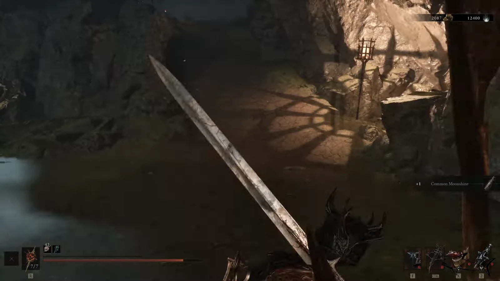 Sword equipped in a torch-lit cavern as a plus one Common Moonshine pickup appears