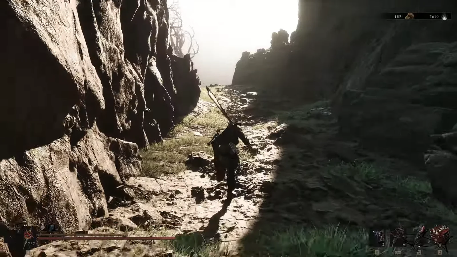 Character carries a long weapon while running along a rocky canyon path toward the grove