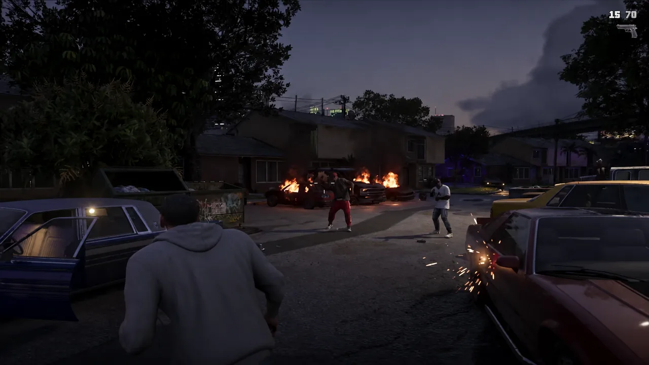 Firing on enemies during a street shootout with vehicles burning nearby