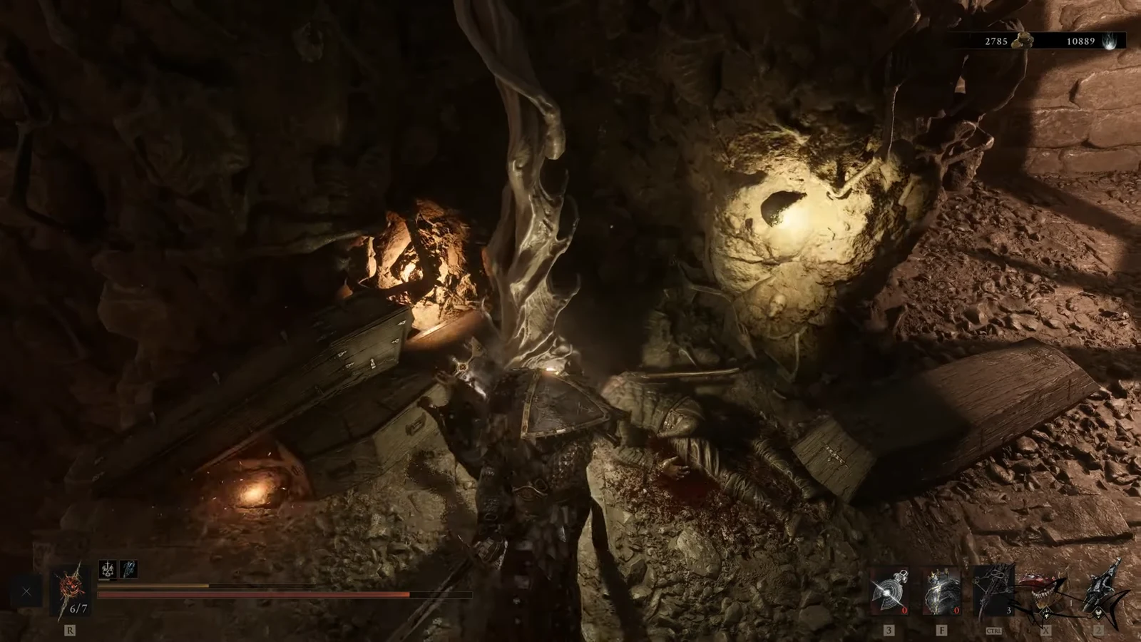 Player looting an open chest beside a corpse in a dim cavern