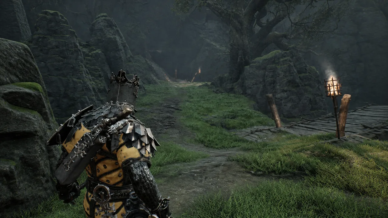 Player following a torch-lit forest path toward a wooden bridge south of the tavern