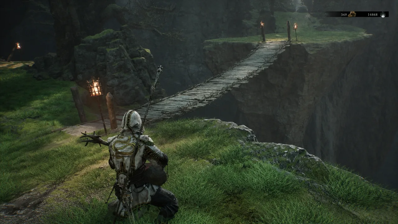 Armored character approaching a torch-lit rope bridge over a deep ravine in eastern Fainweald