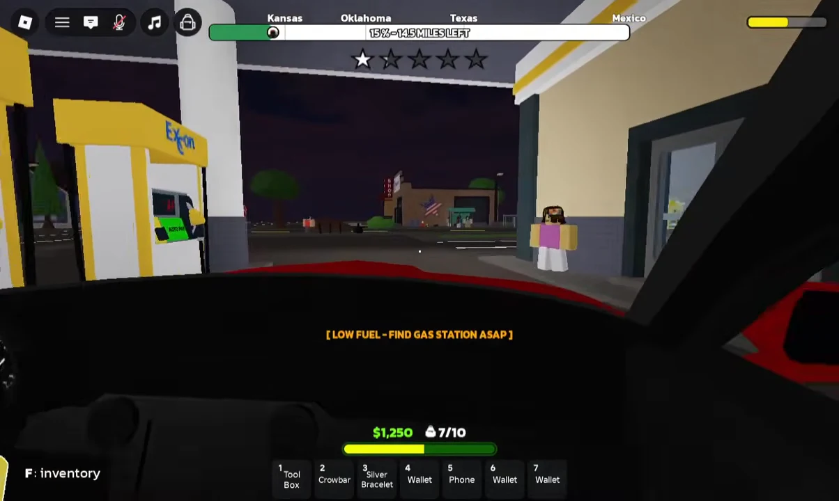 Driving view with a low fuel warning as the car approaches an Exxon station to refuel