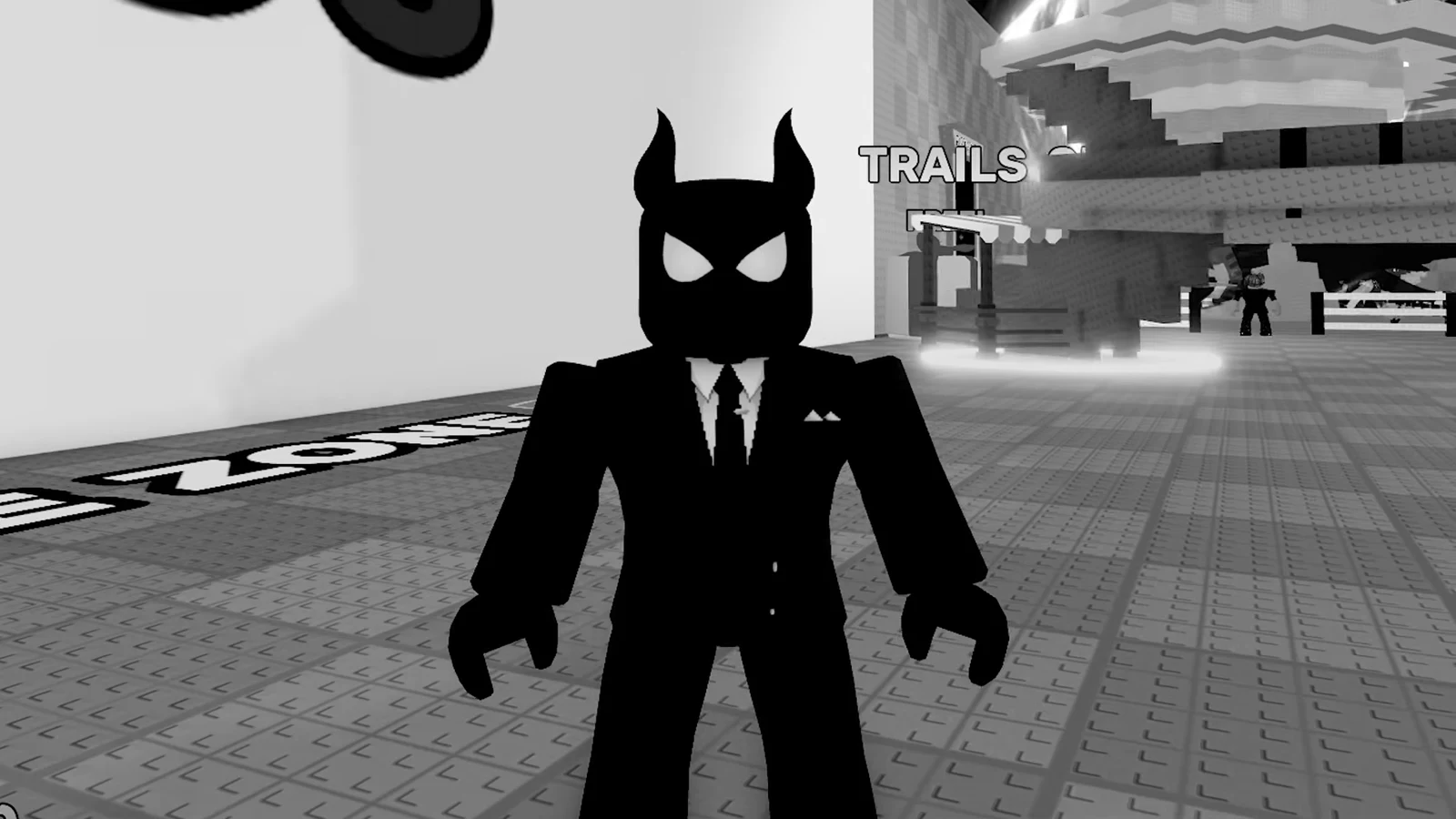 Black-suited avatar standing in the lobby beside the TRAILS area