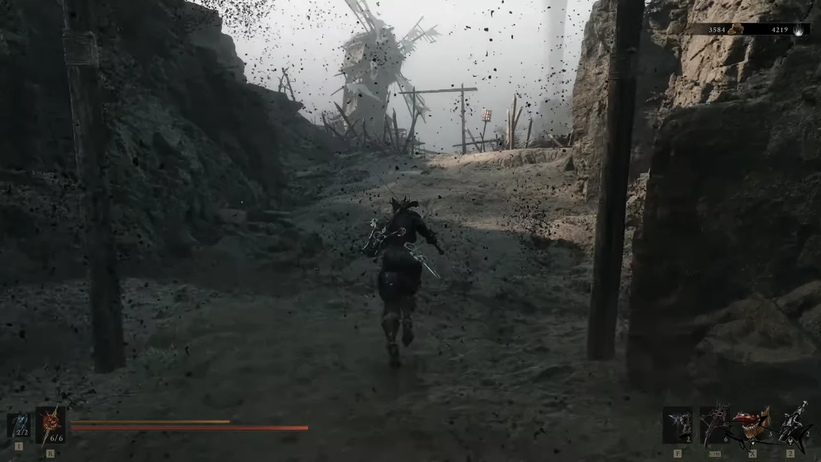 Character running up a bleak ravine toward a windmill with the combat HUD visible