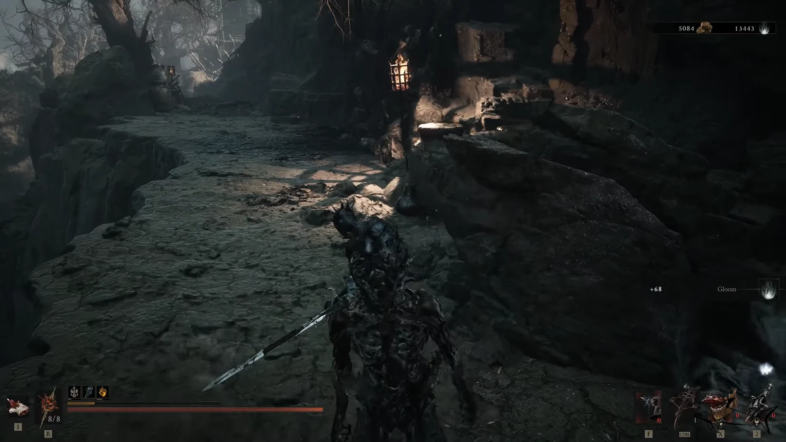 Armored Harbinger with sword drawn moving along a torch-lit rocky path toward the gate