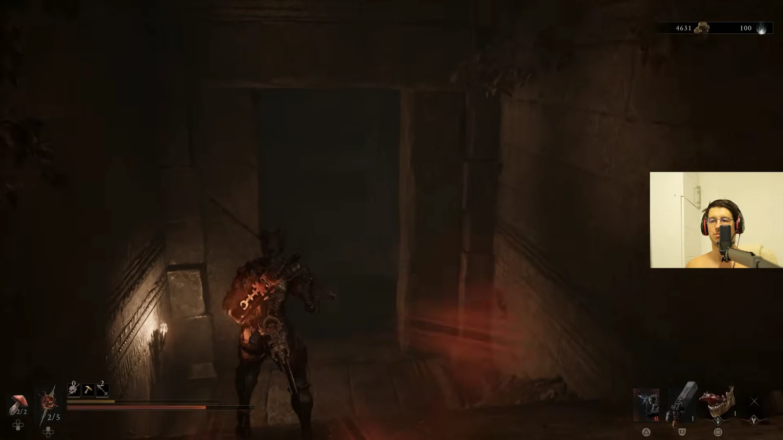 Player advancing through a dark stone corridor toward an open doorway with weapons and health on the HUD