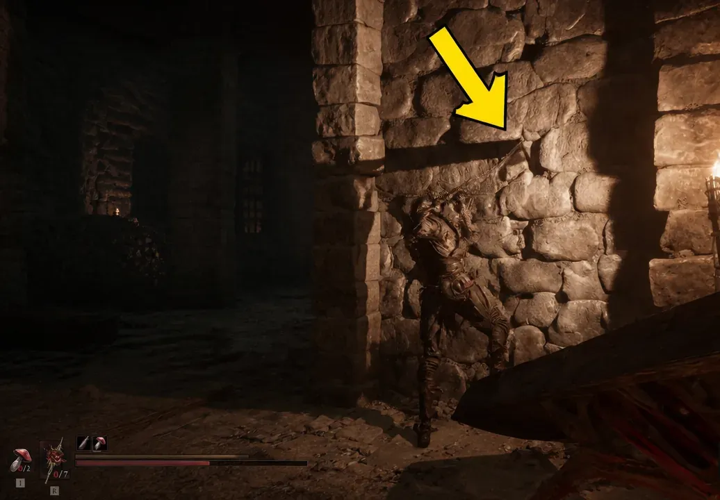 Player faces a small dark opening in the stone wall marked by a yellow arrow as a hidden passage