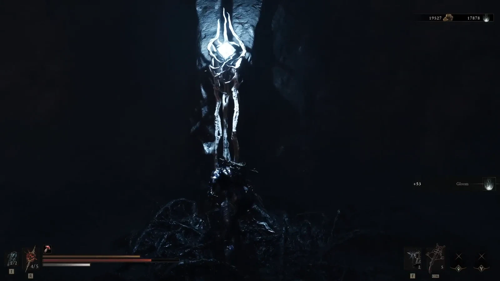 Armored character standing under a glowing white shrine in a dark cavern