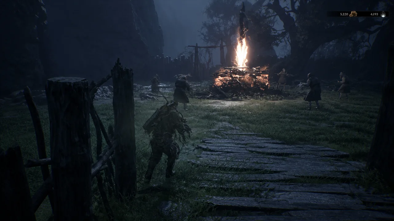 Player creeping past enemies gathered around a blazing campfire on the wooden path