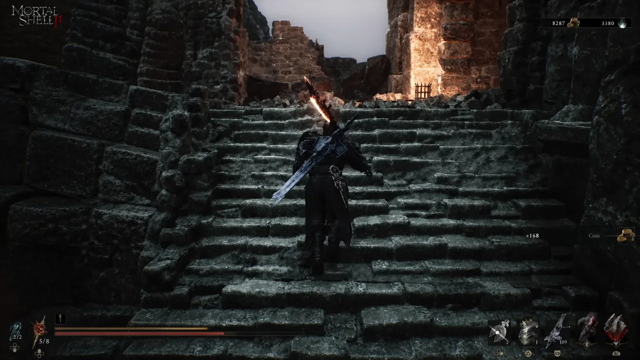 Stone staircase climbing toward the lit entrance of the ruined structure
