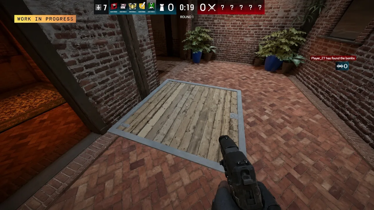 First-person view aiming a pistol at a closed wooden floor hatch in a brick corridor