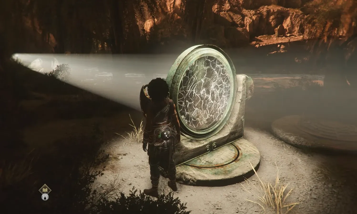 Sophia stands beside a large cracked circular mirror mechanism inside a cavern