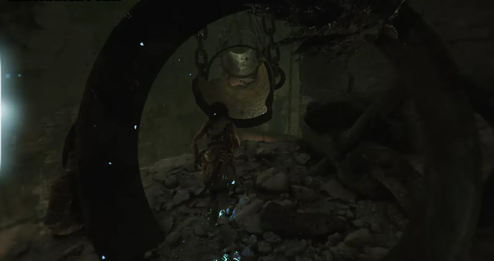 Sophia moving through a dark cavern toward a large suspended metal structure