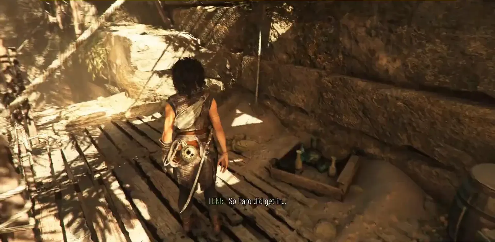 Sophia crossing a wooden scaffolding platform inside the rocky canyon camp in Chapter 4
