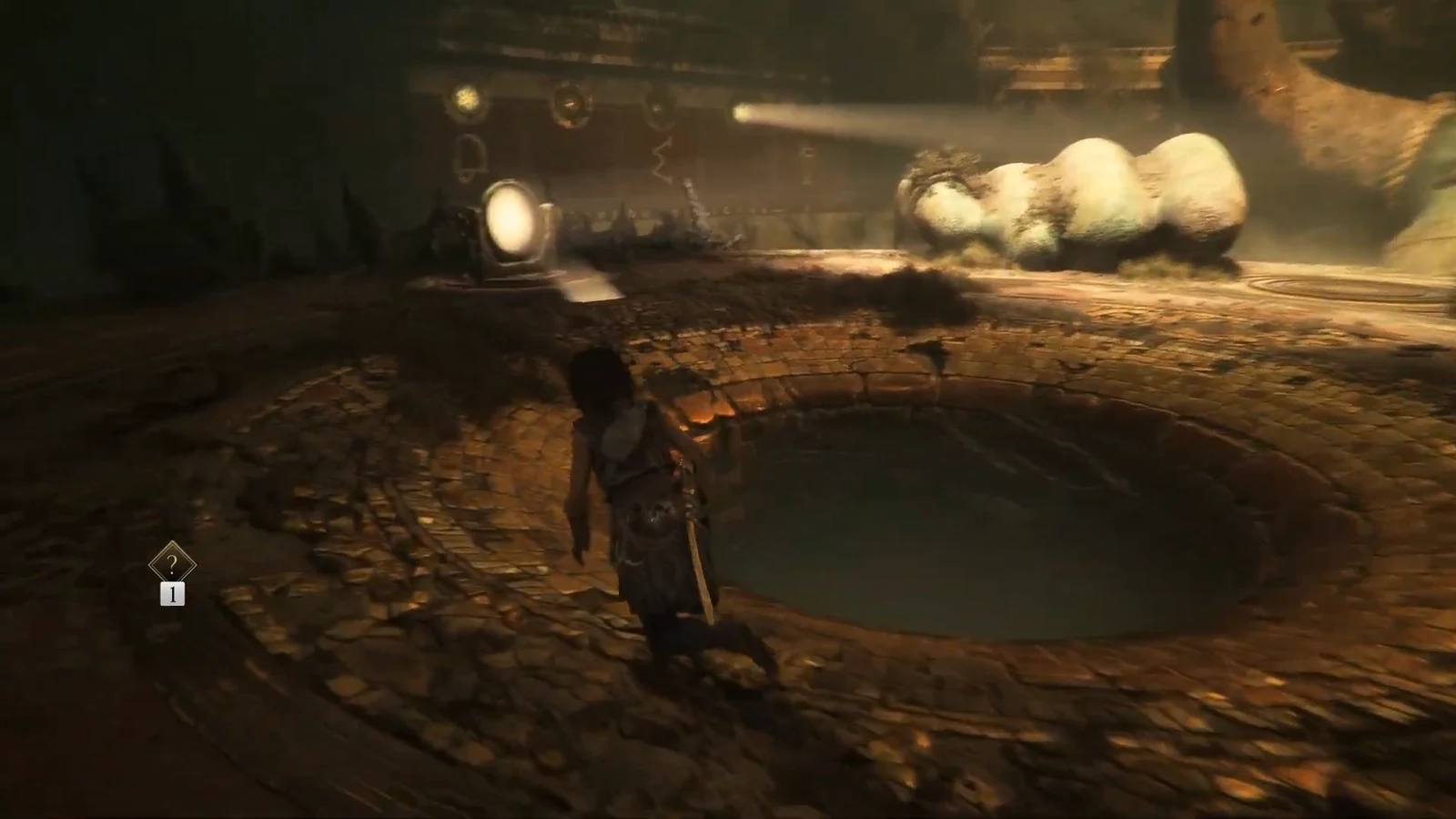 Sophia walks toward the circular left mirror platform in the dim arena chamber