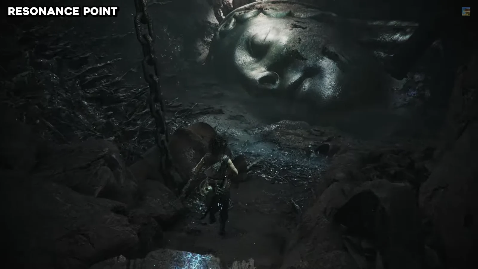 A colossal stone face lying on the ground in the cavern where Sophia drops down