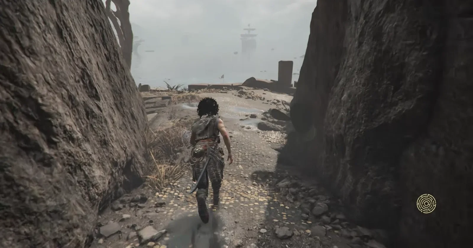 Sophia walking through a rocky passage that leads down toward the shoreline