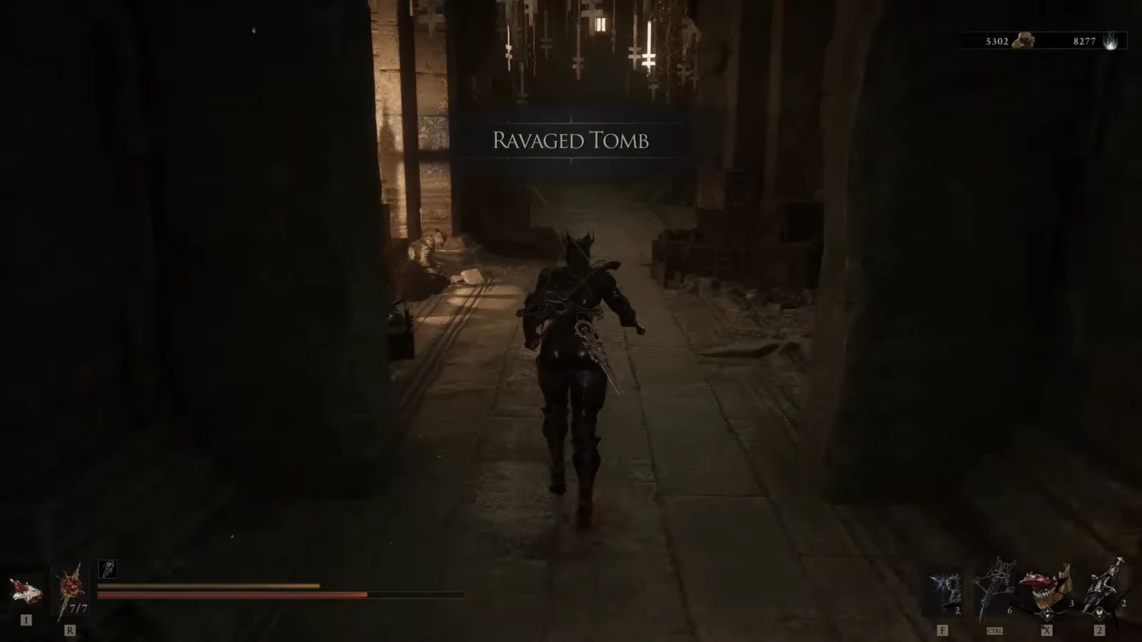 Ravaged Tomb area title on screen as the character runs through a dark tomb corridor
