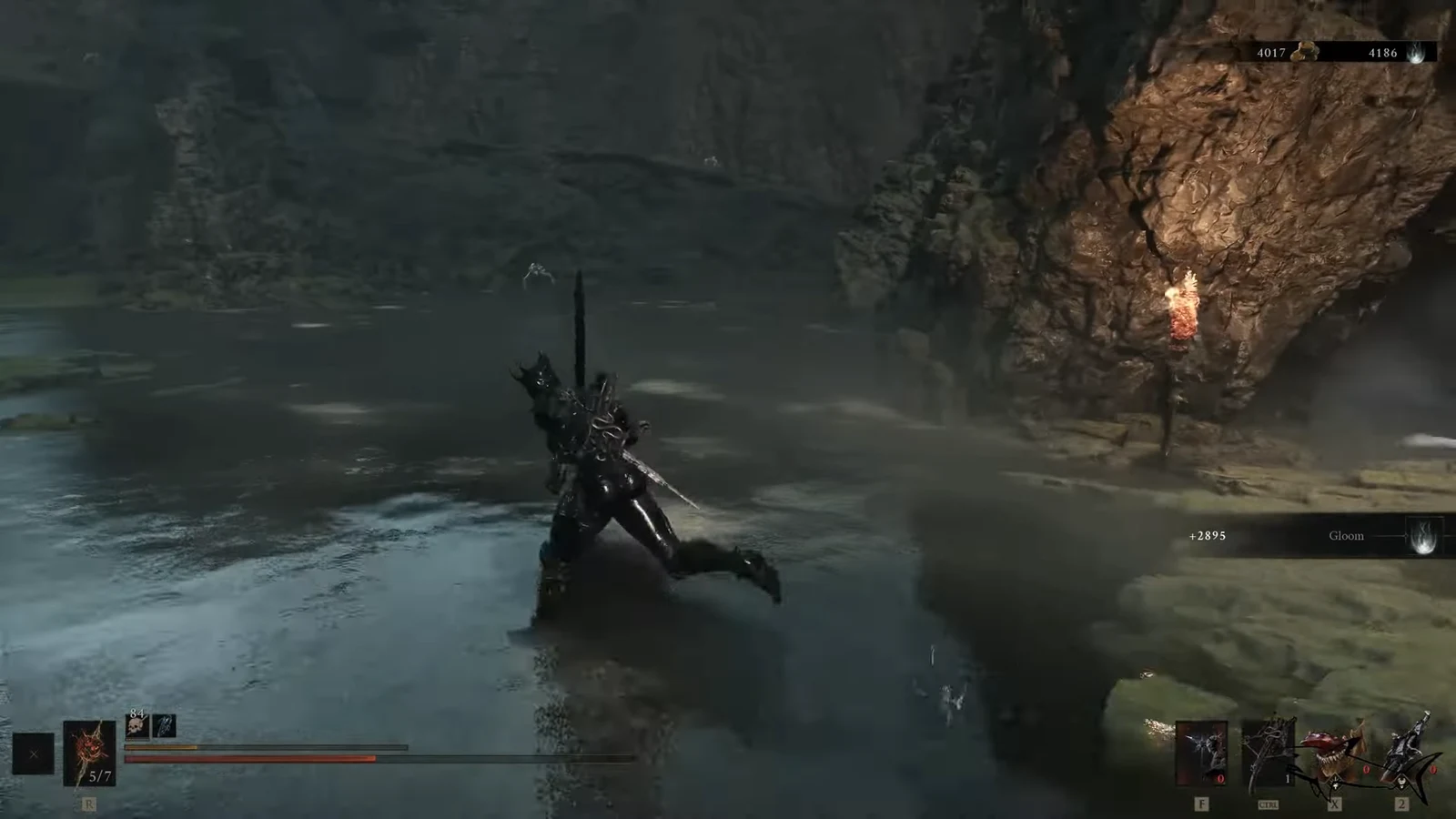 Armored character wading through a flooded cavern toward a torch-lit rocky shore