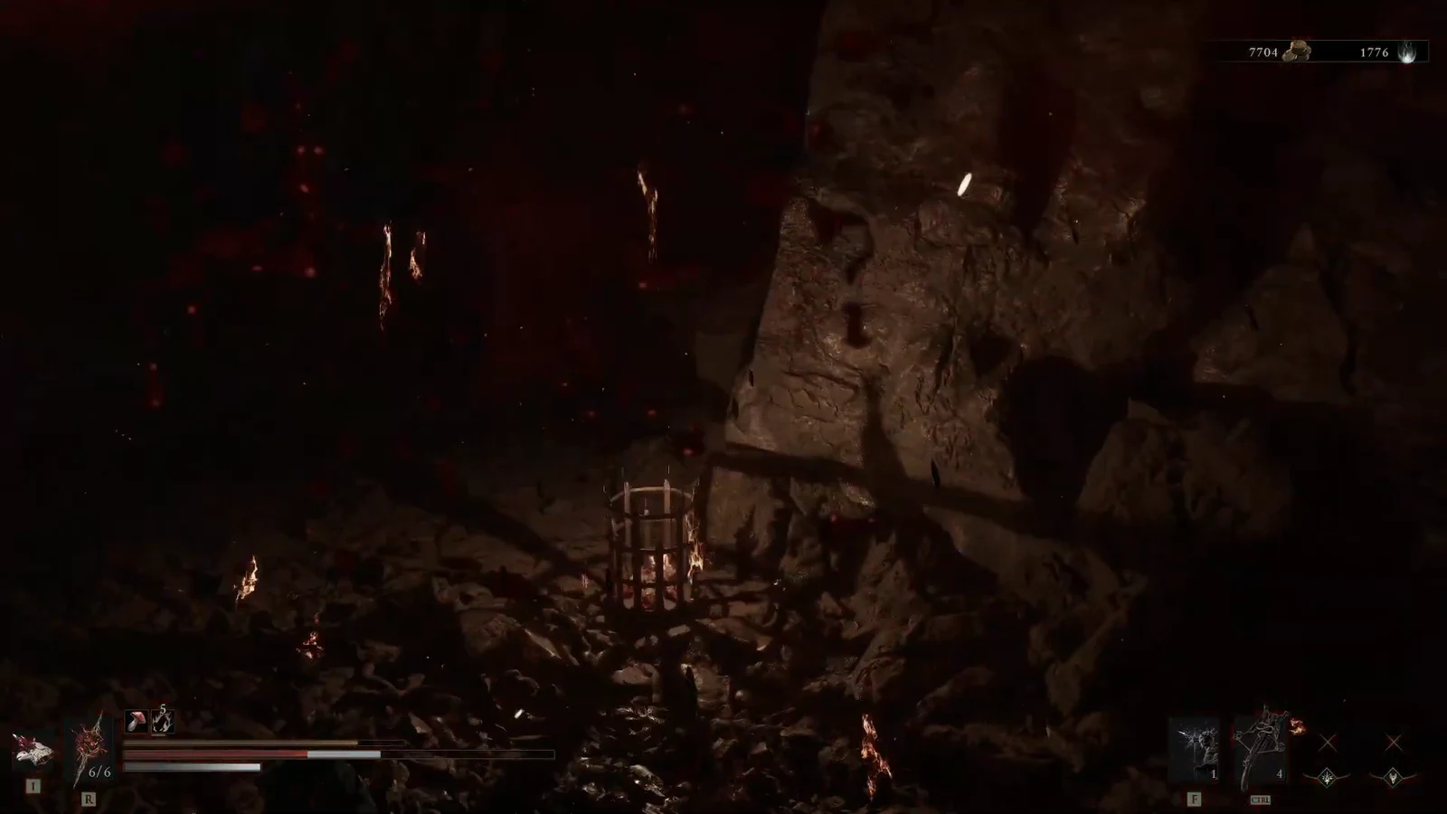 Character approaching a small iron cage in a dark, fiery cavern after crossing a bridge