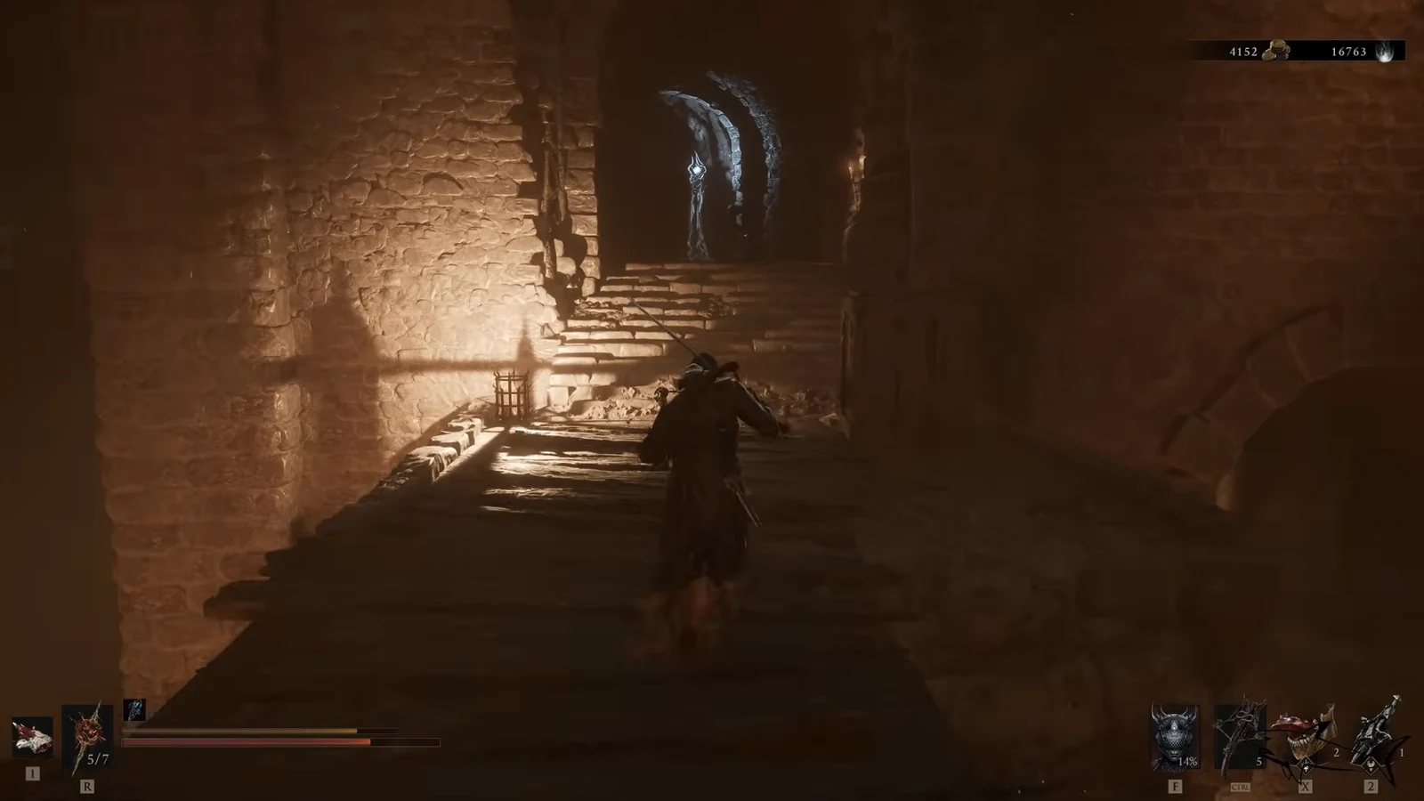Player heading down a torchlit stone corridor toward stairs and an arched doorway