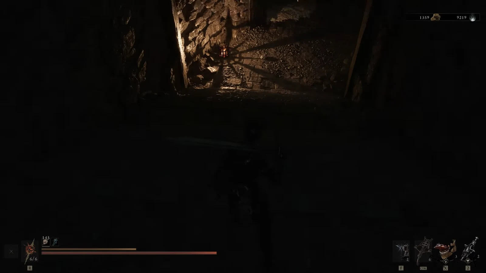 Player character moving through a dark torchlit stone passage with the combat HUD visible