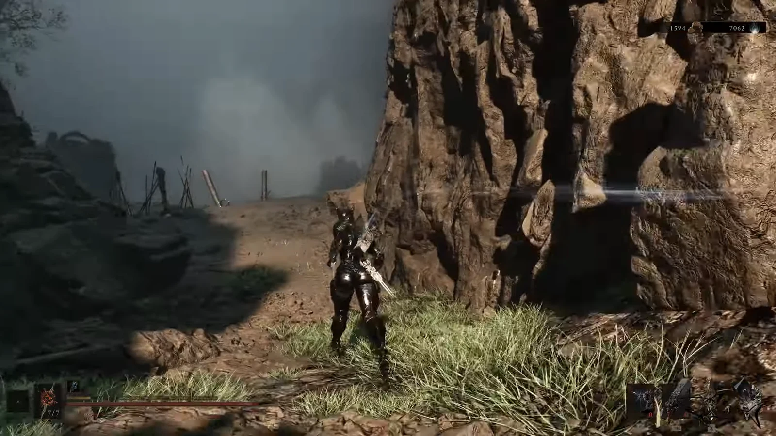 Armored player character crossing a rocky cliffside path with a weapon drawn