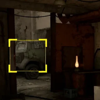 A truck marked with yellow brackets seen through a doorway on the route north of Slag Heap