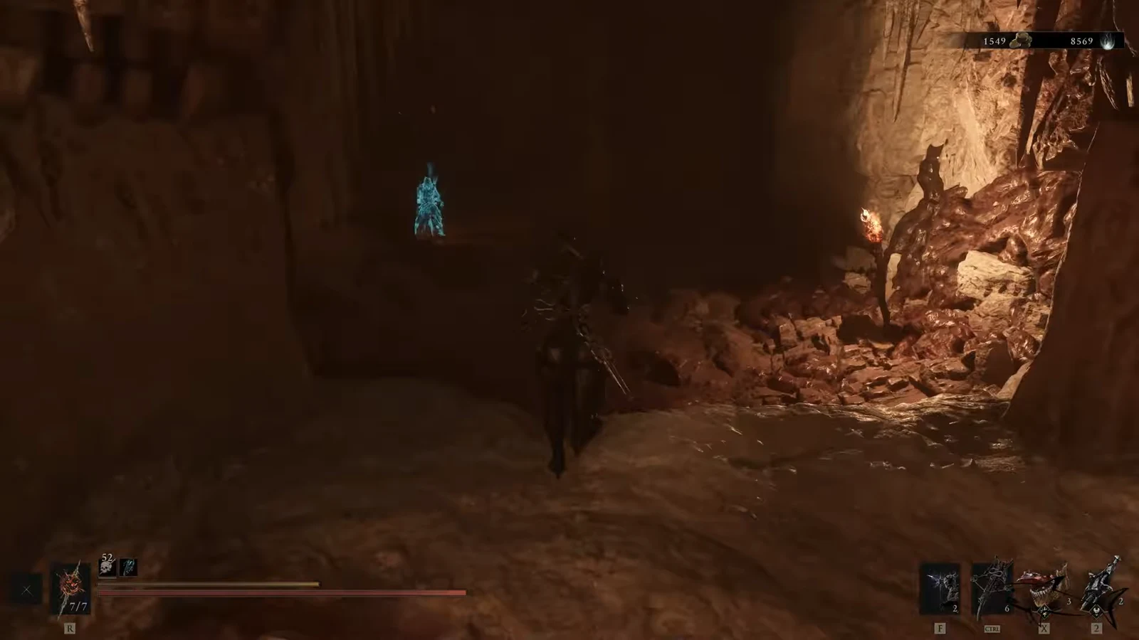 Player advances through a torchlit cavern toward a glowing blue figure, with HUD elements visible