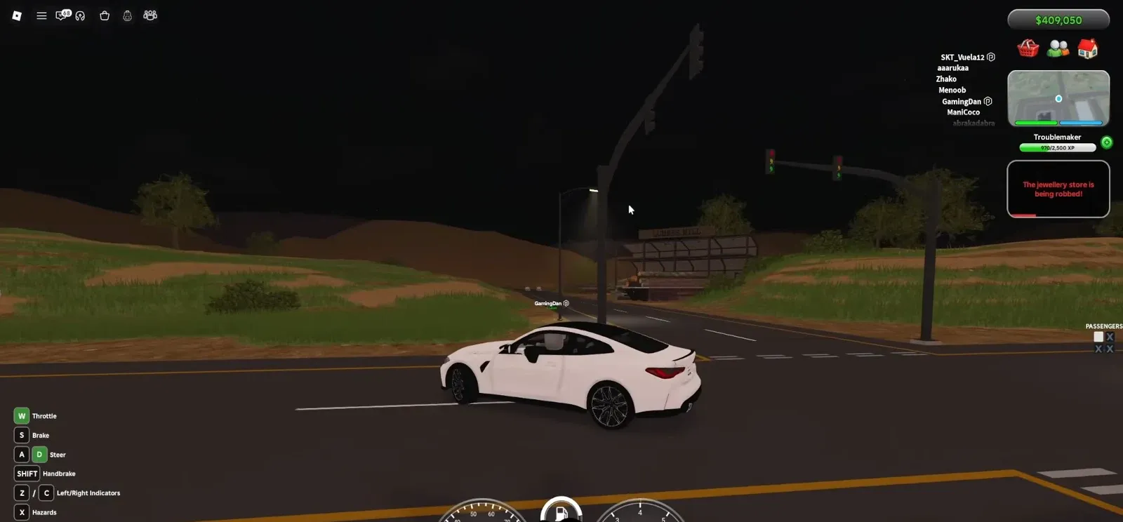 Driving a white car at night toward the Lakeside Mall intersection with the driving HUD visible
