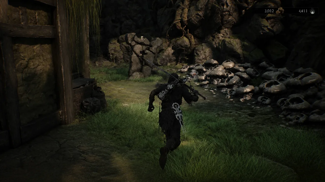 Player wielding a weapon running through a grassy rocky area beside a pile of skulls