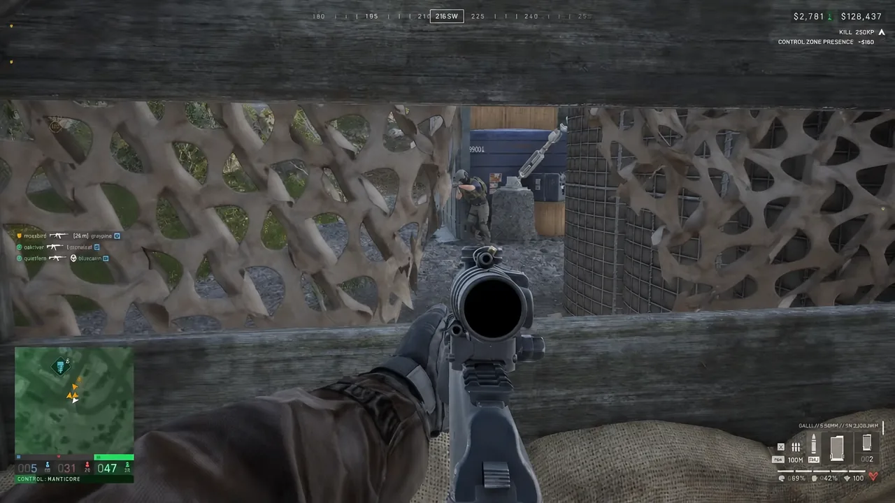 Rifle optic view through leafy cover with an enemy soldier in the sights