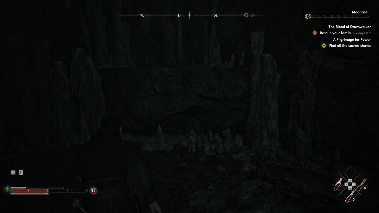Coen exploring a dark cavern interior with the quest tracker visible on screen