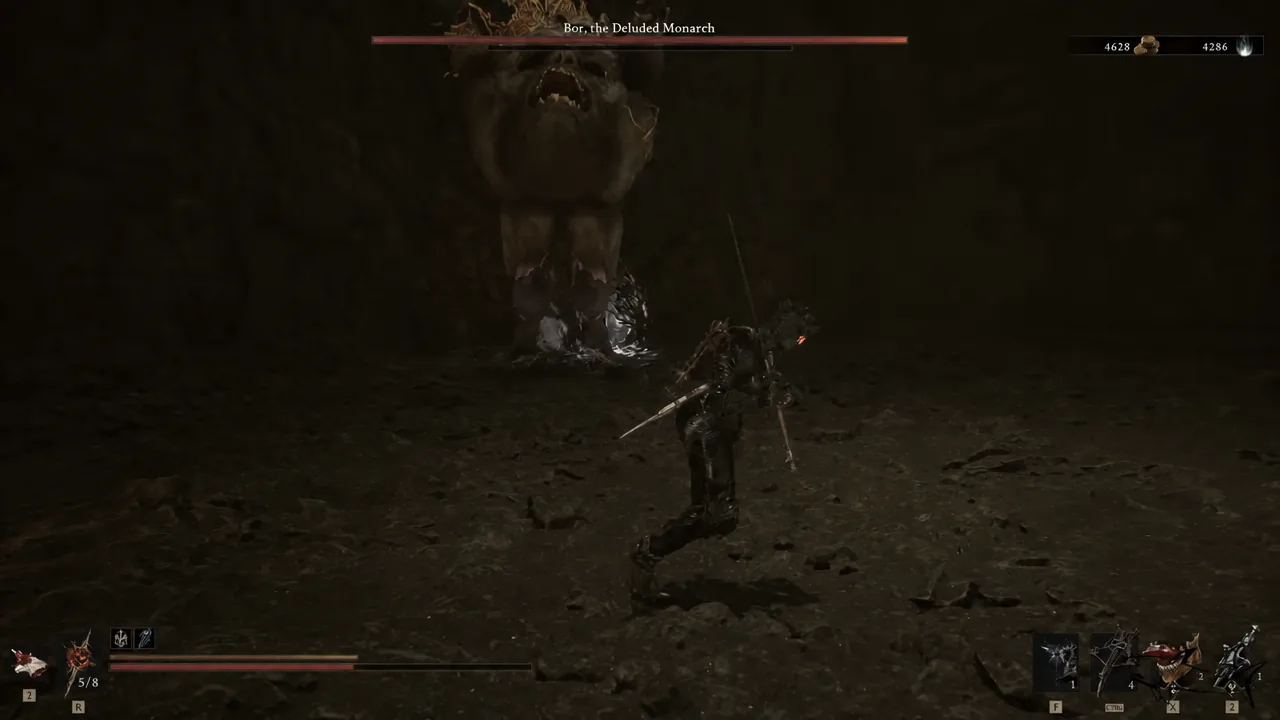 Player character squaring up against the towering Bor boss inside the dark cave arena