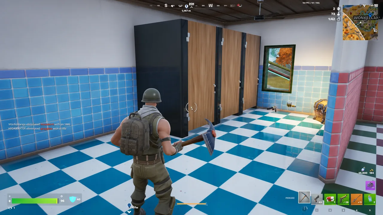 Player with the pickaxe selected breaking objects inside a tiled restroom