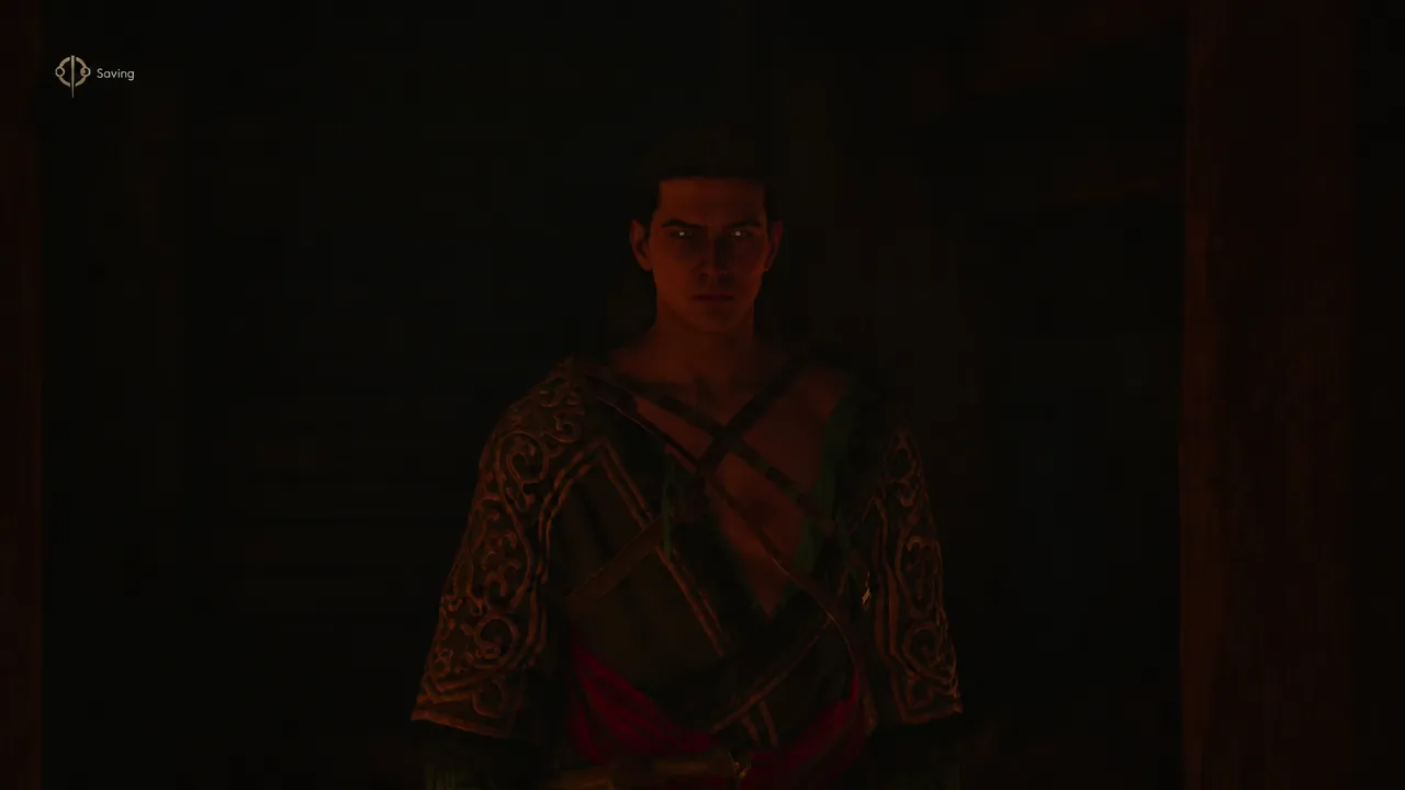 Coen standing in the ruins while the on-screen Saving indicator is active