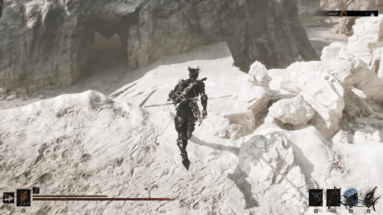 Armored player character running over rocky ground toward a cave mouth with the HUD on screen.