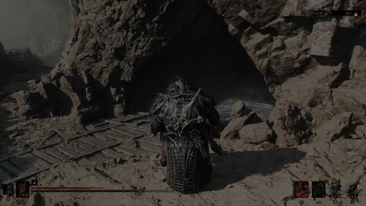 Player approaching a dark cave entrance set into a rocky wall