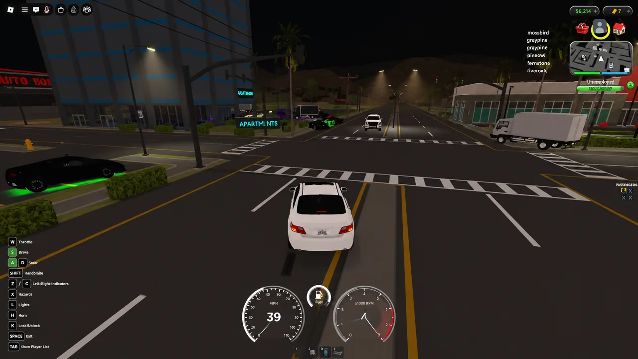 White car driving through an intersection with the speedometer reading 39 MPH