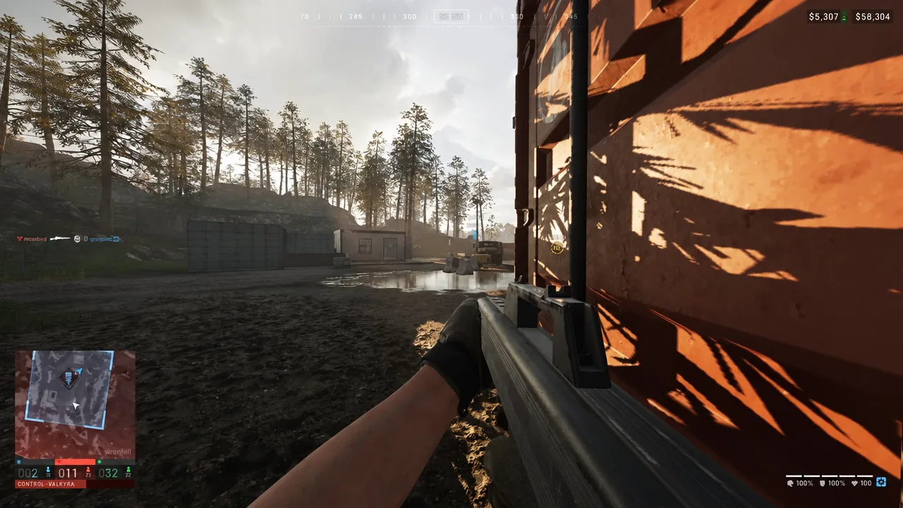 Wardogs player holding an angle with a rifle beside an orange wall