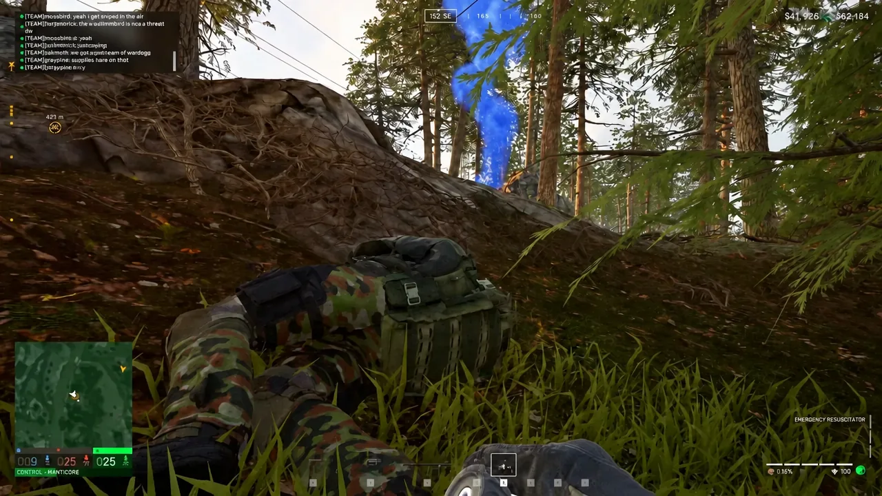 Player prone with the Emergency Resuscitator equipped and a blue objective beacon ahead