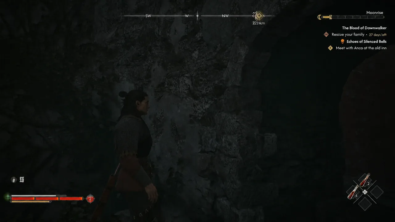Player exploring a dark cave interior with the quest tracker visible on the HUD