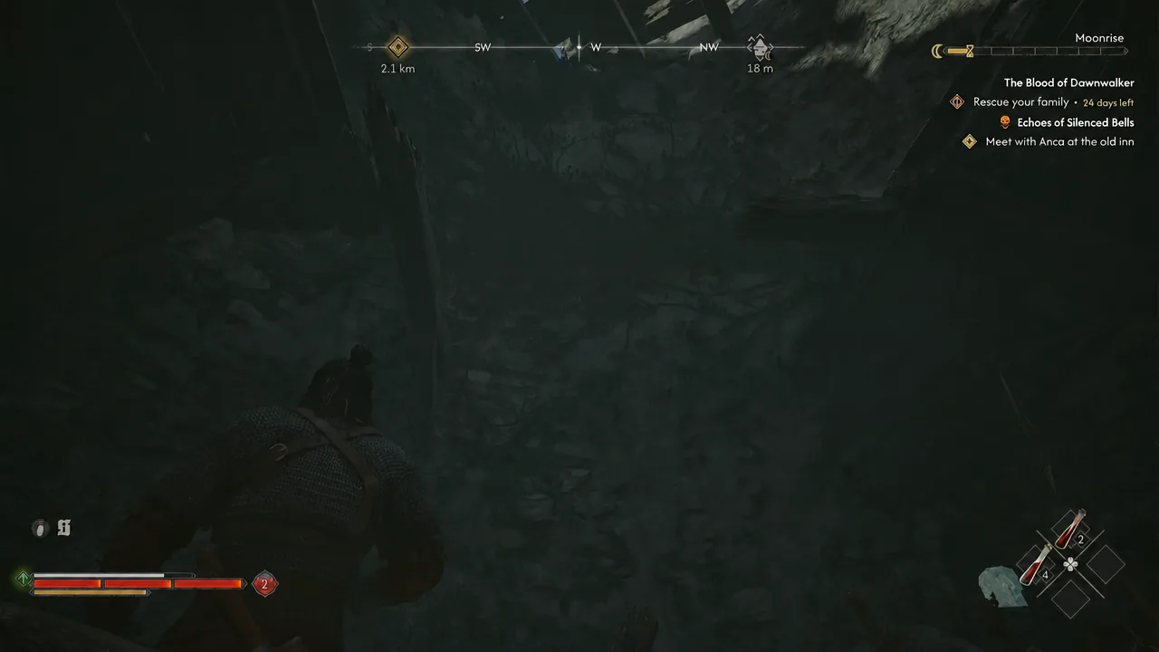 Dark cavern approach with the compass and quest tracker pointing at an objective 2.1 kilometres away
